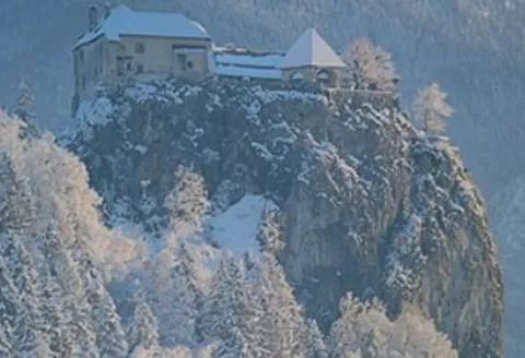 Bled Castle on its cliff above the lake, under snow