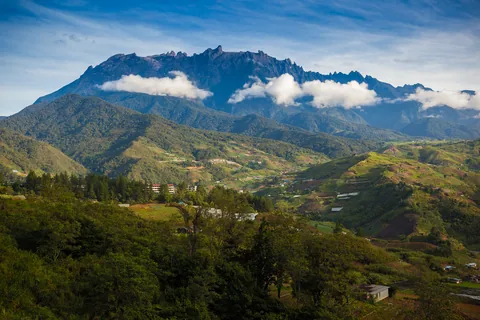 Mount Kinabalu in the morning above green Sabah hill country