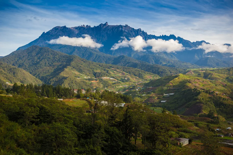 Mount Kinabalu in the morning above green Sabah hill country
